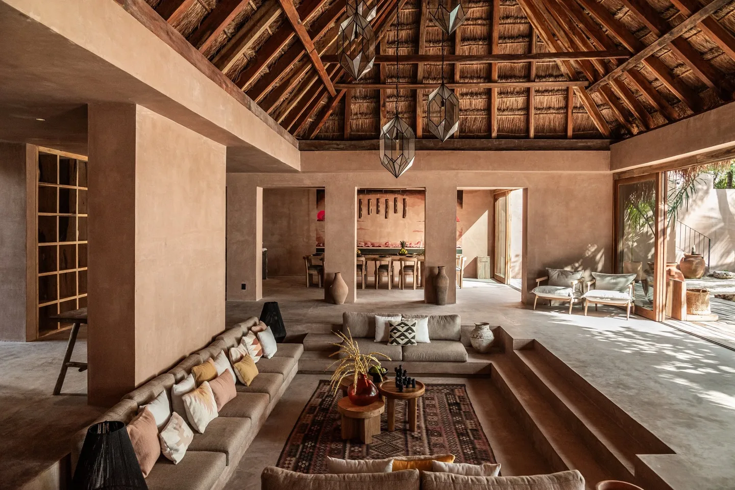 The living room at XELA with a wooden ceiling and beige walls
