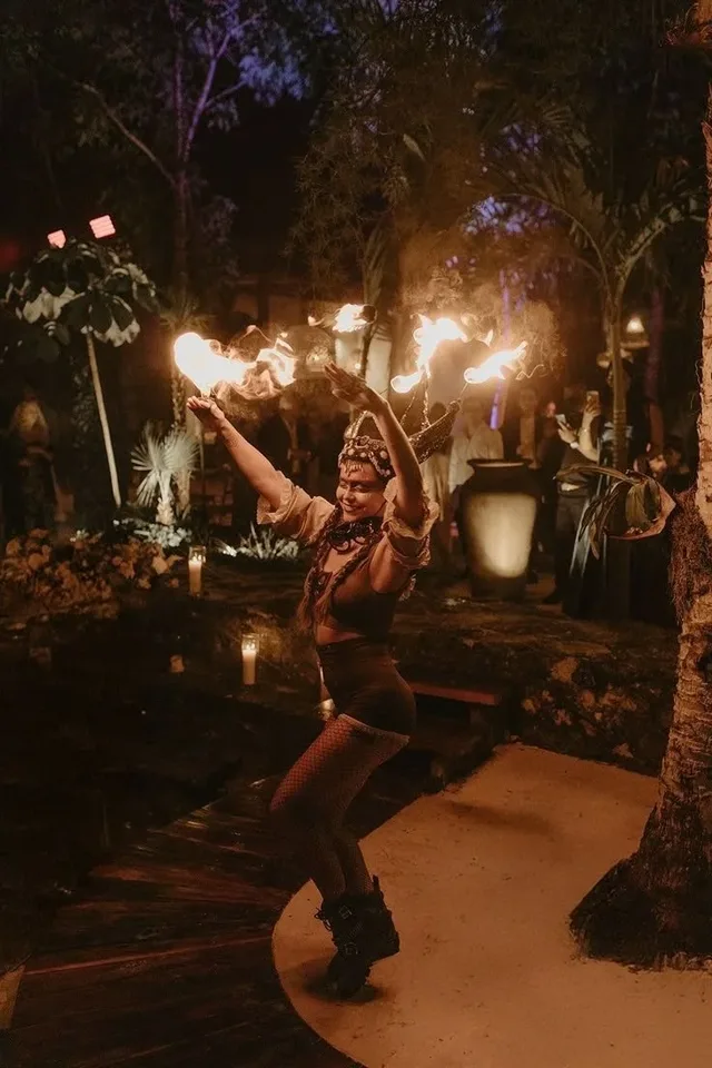 A fire dancer with torches at night