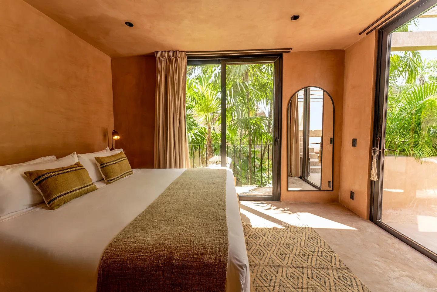 King bed facing floor-to-ceiling doors onto the garden
