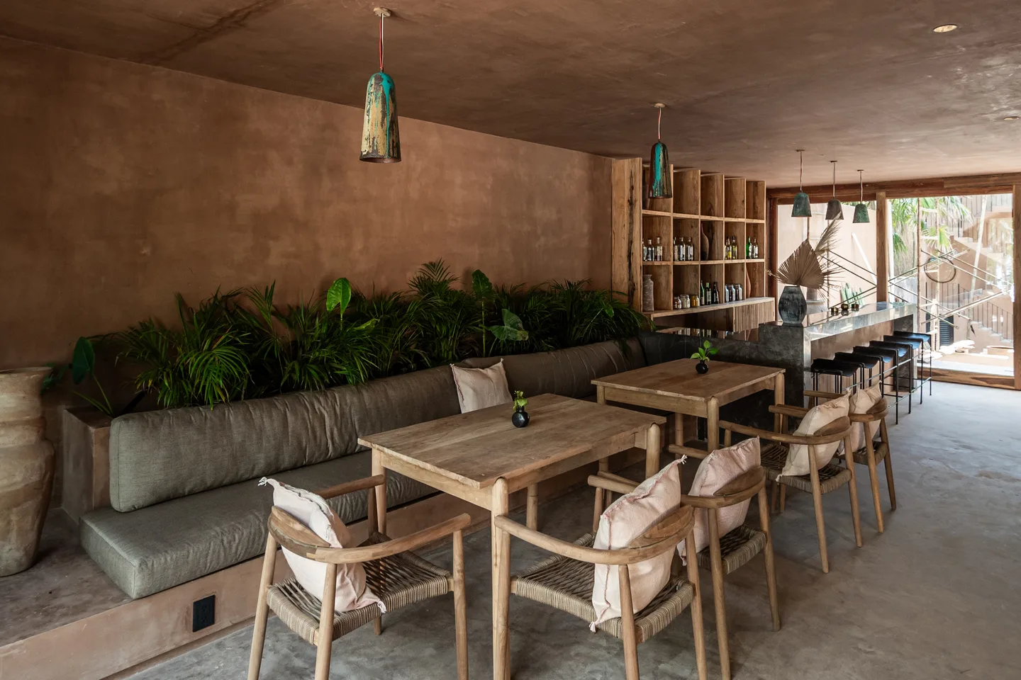 Restaurant banquette seating and wooden tables leading to the bar