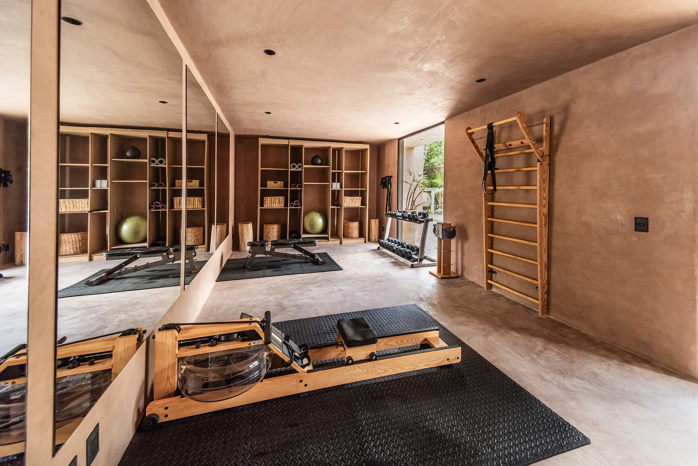 Gym with a wooden water rower, exercise mats and wall bars