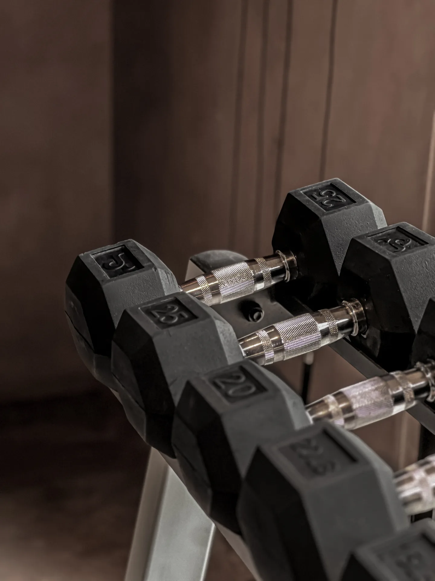 Close-up of black hex dumbbells on a rack