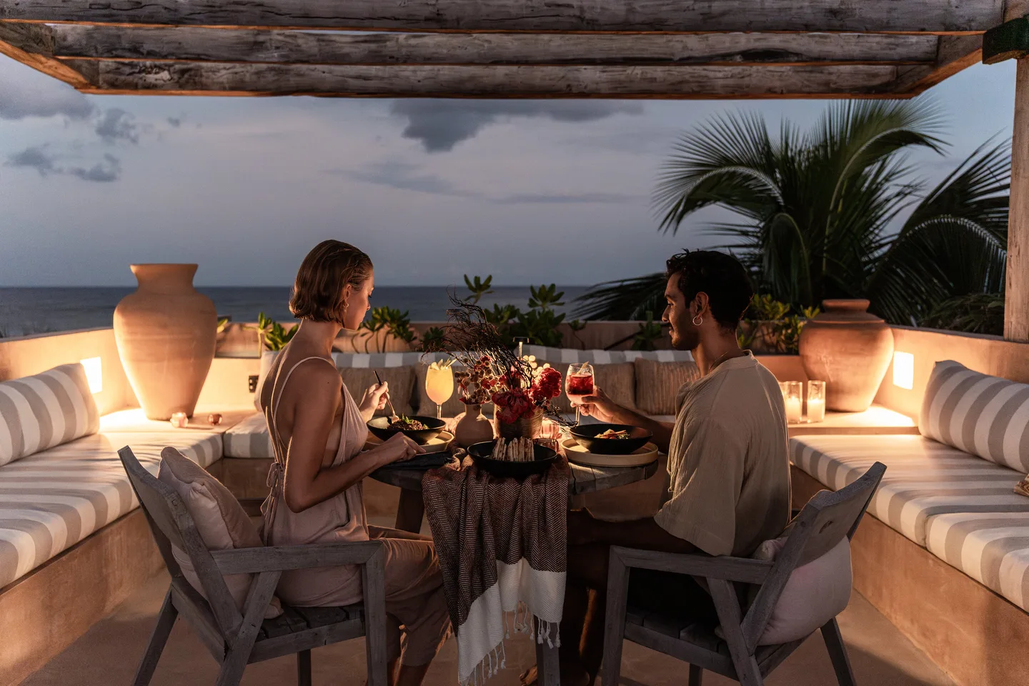 Couple at a candlelit private dinner on the rooftop at dusk