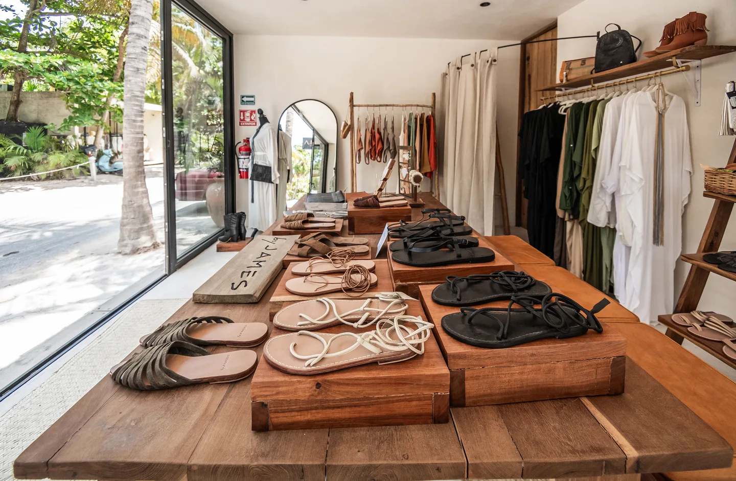 Handmade leather sandals displayed on a long wooden table in the boutique