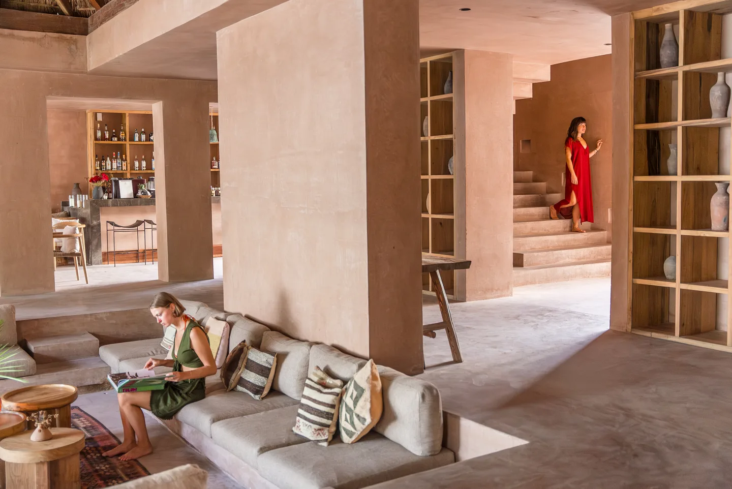 Guest reading on the sunken lobby sofa while another climbs the staircase