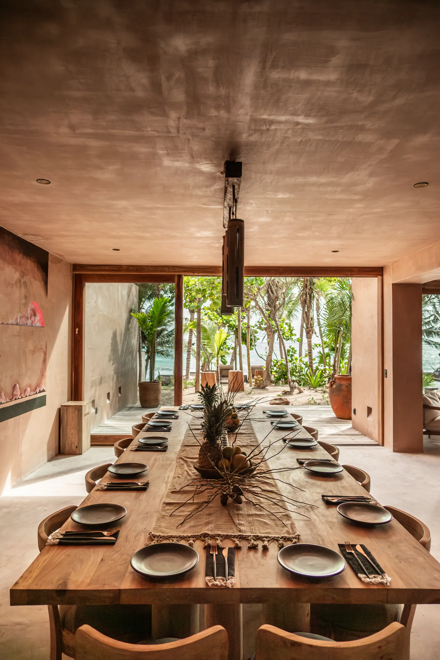 Long dining table set for a group with doors open to the garden
