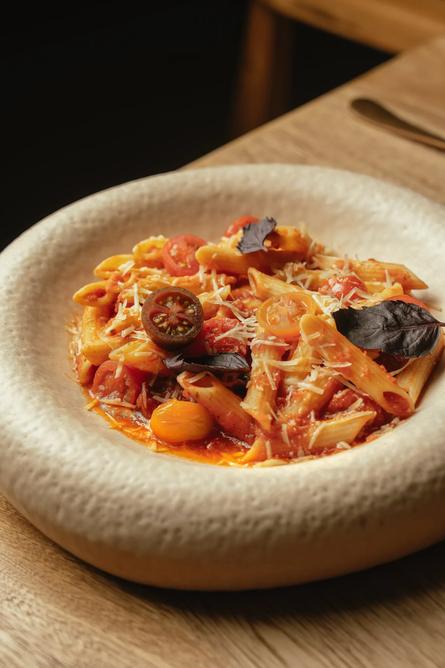 Handmade pasta in tomato sauce with basil in a stoneware bowl