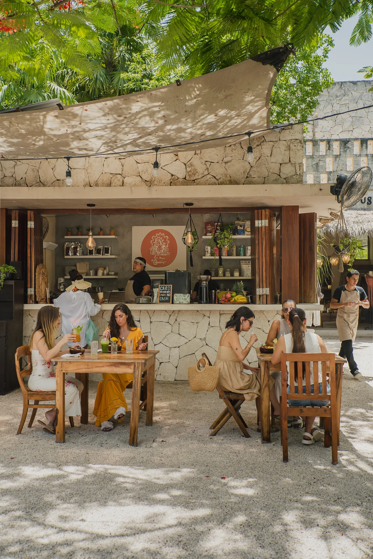 Guests at outdoor tables in front of the Los Bowls de Guadalupe counter